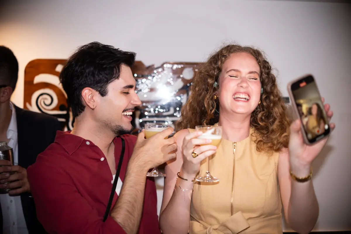 Two guests laughing, cocktails in hand