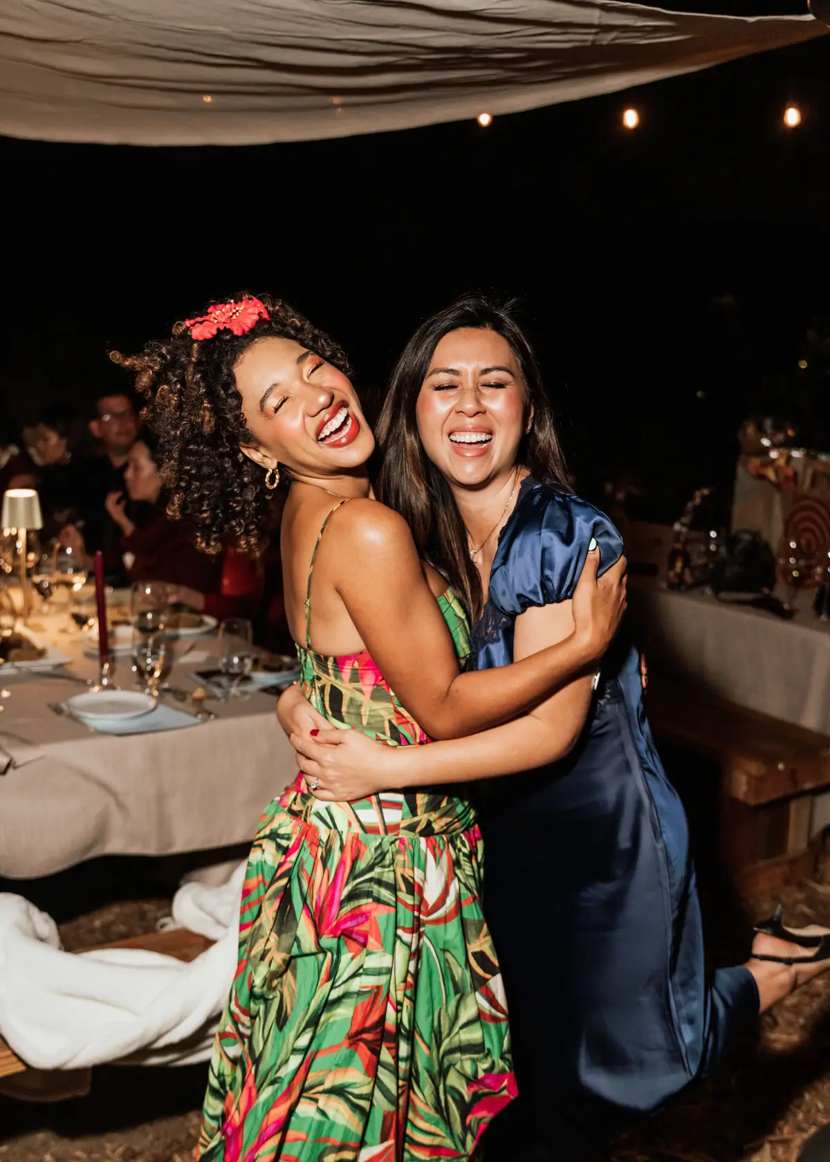 Two guests hugging and laughing