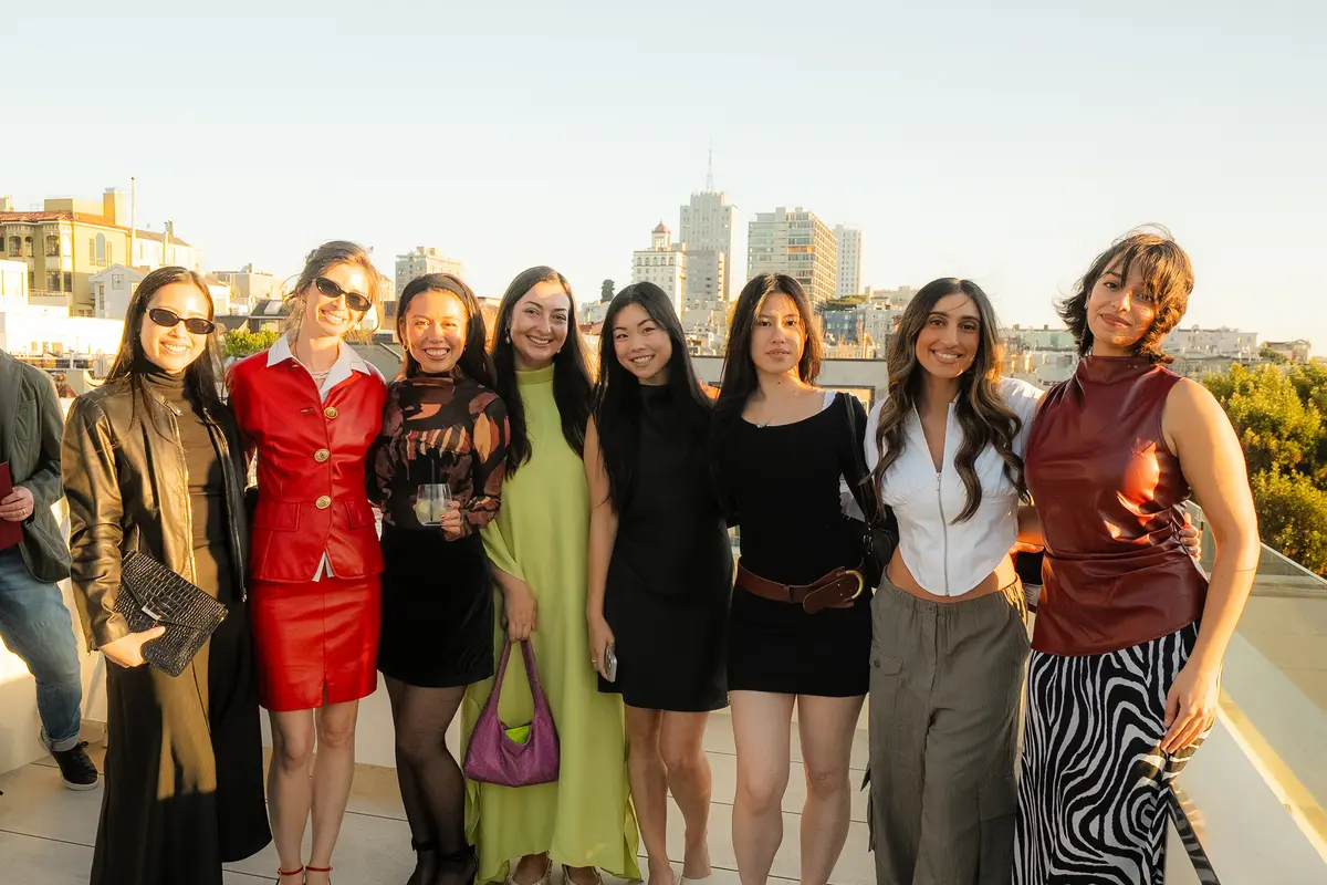 The guests on a rooftop, the San Francisco skyline behind them