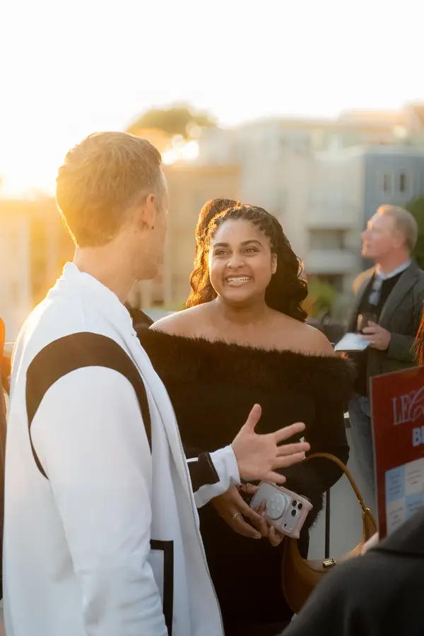 Guests talking at sunset on the rooftop